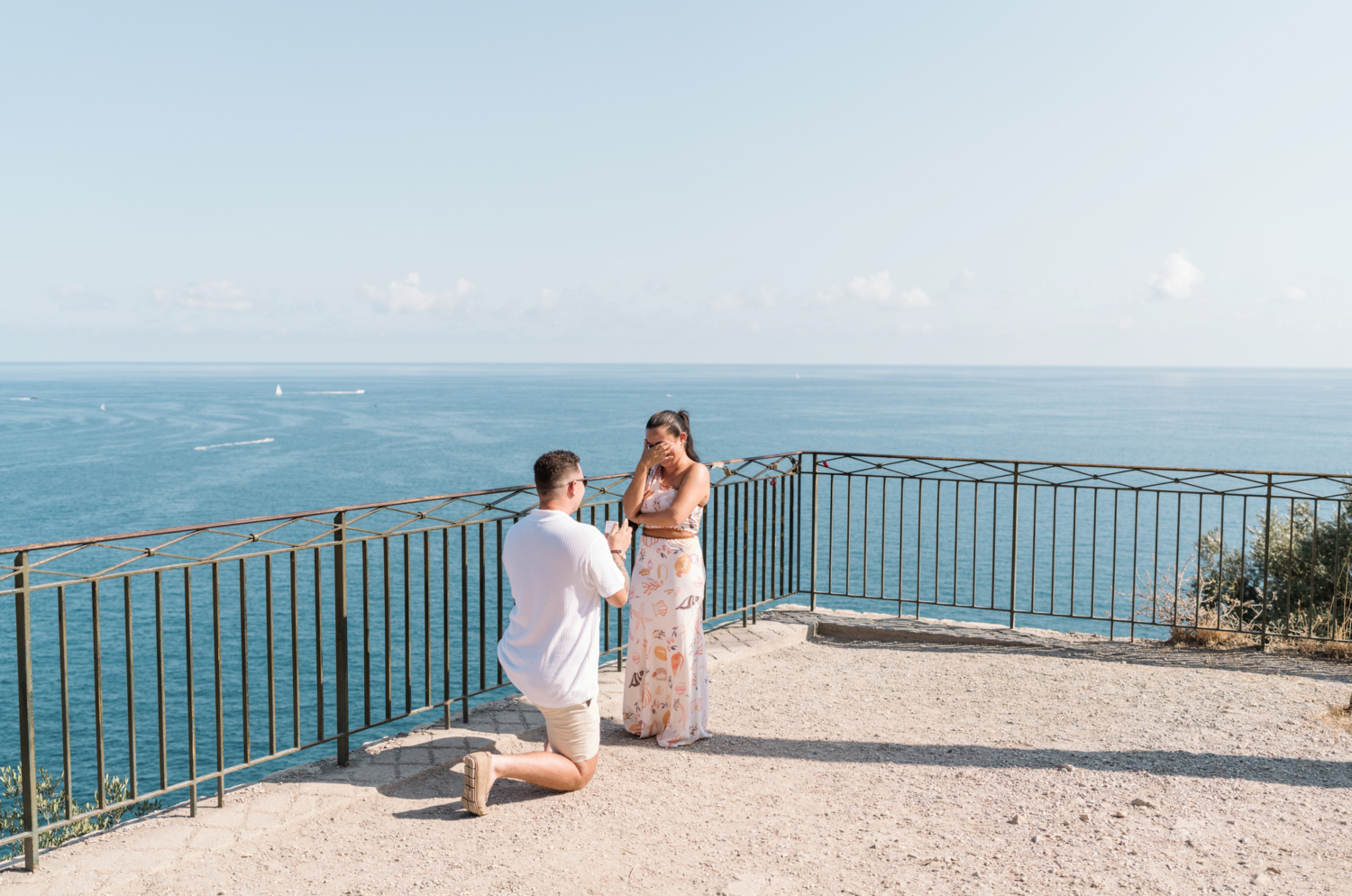 woman is shocked her boyfriend is proposing with view of sea in nice france