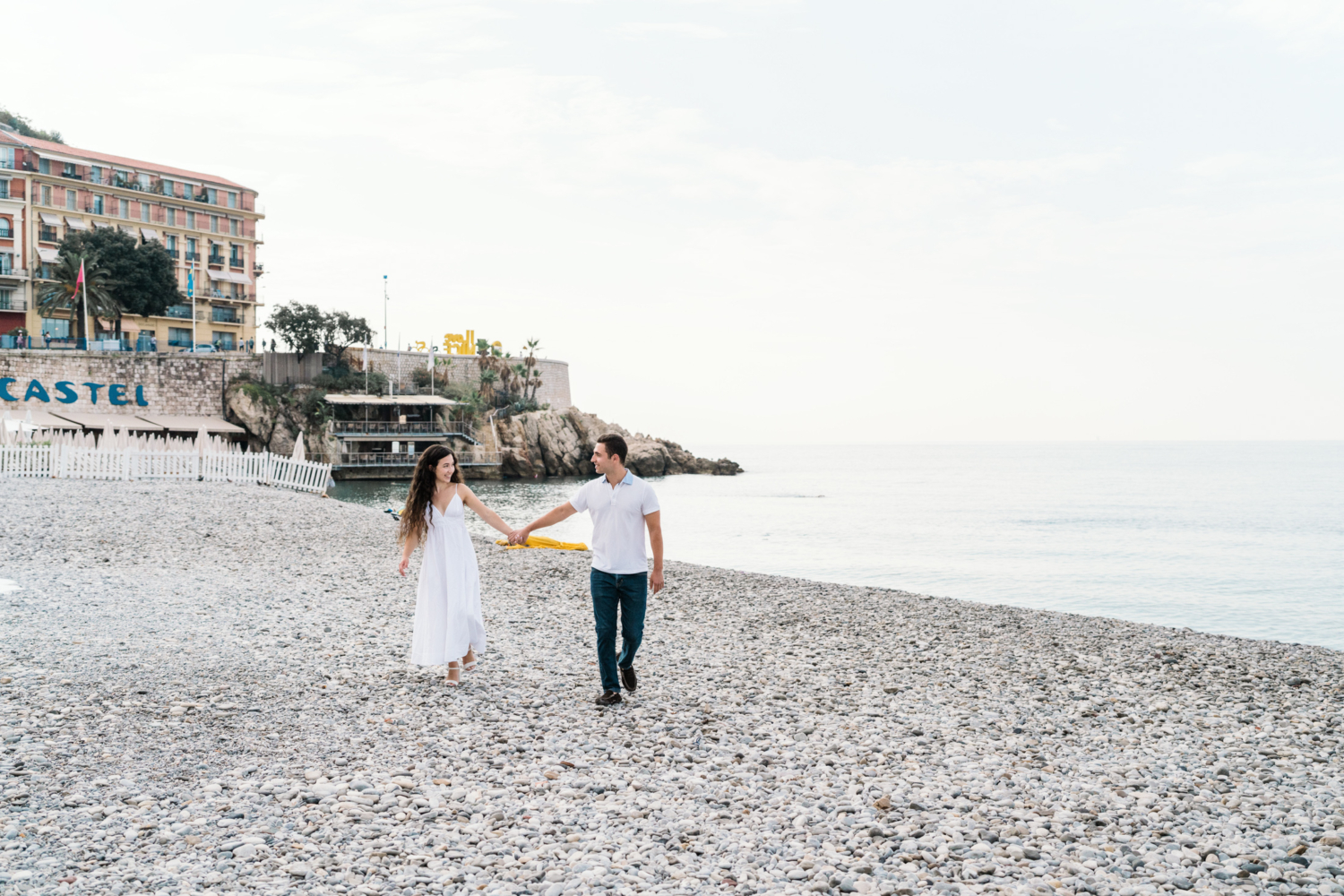 cute laughing couple walk on the beach in nice france