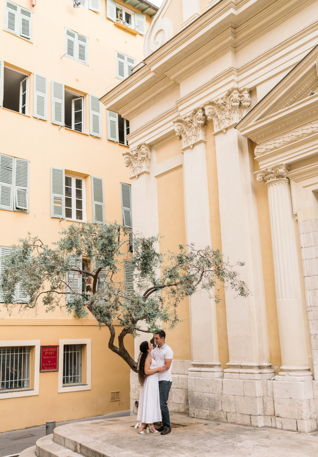 beautiful couple pose under tree in old town nice france