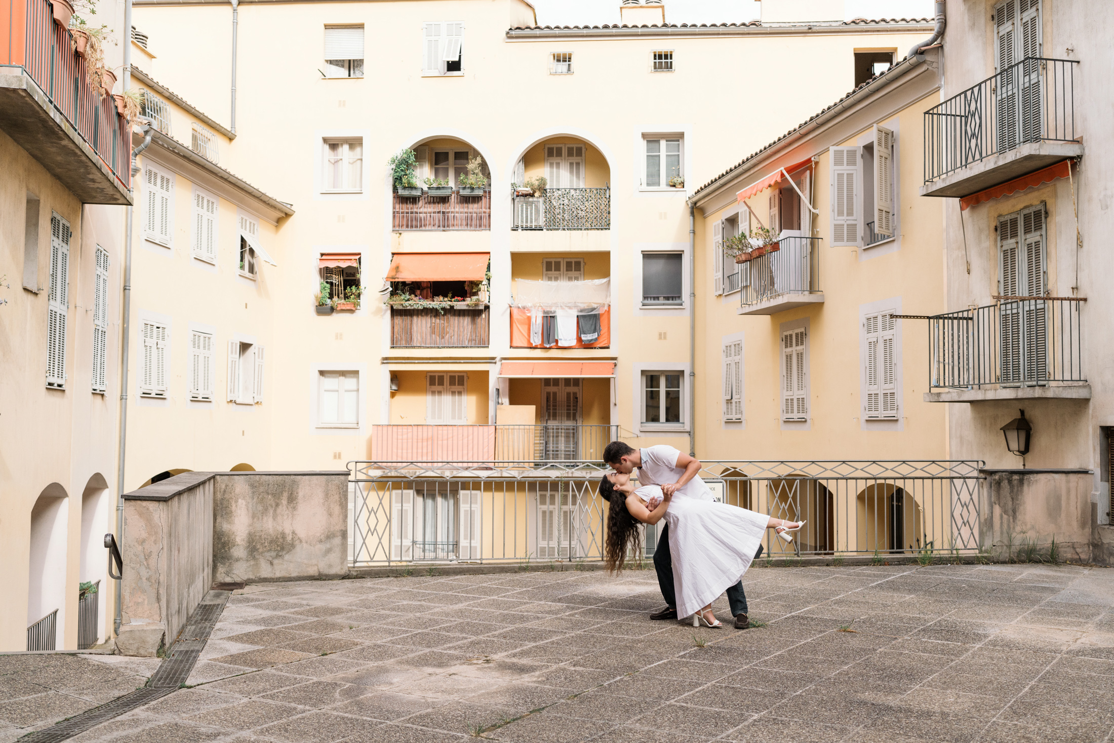 engaged couple dance around colorful buildings in nice france