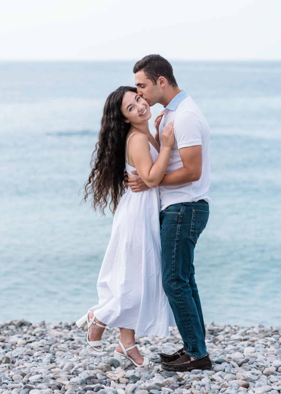 man kisses cheek of woman on beach in nice france