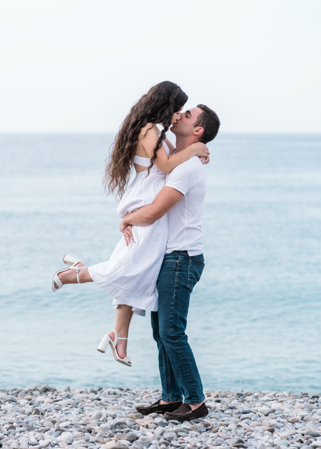 man lifts fiancee at the beach in nice france