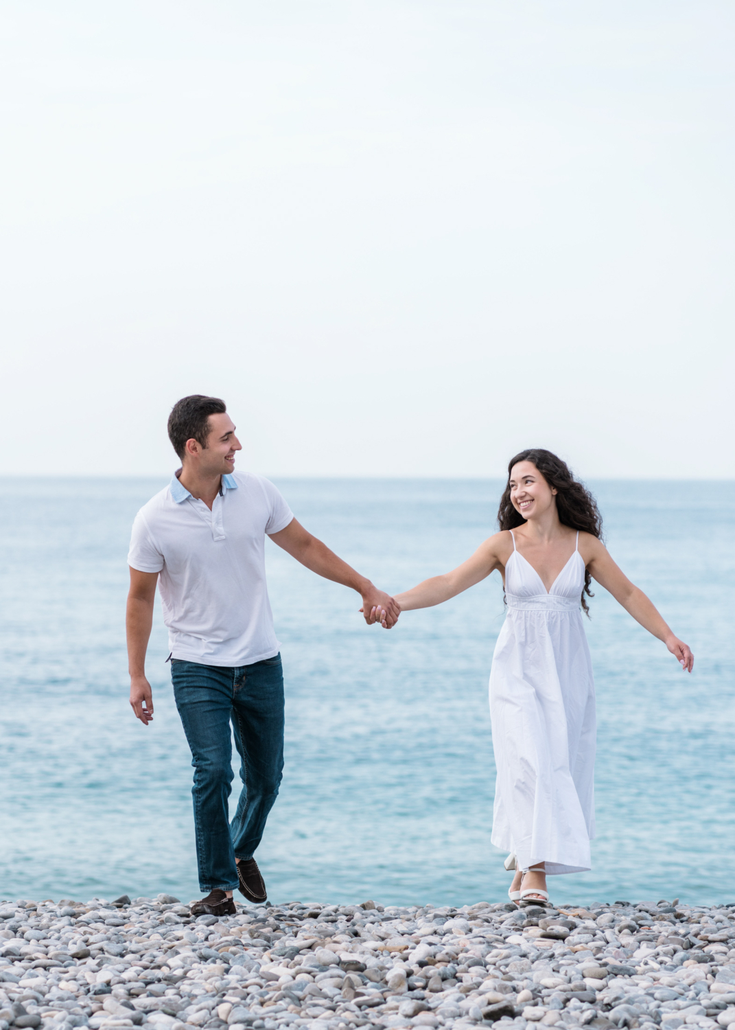 engaged couple walk on beach with view of sea in nice france