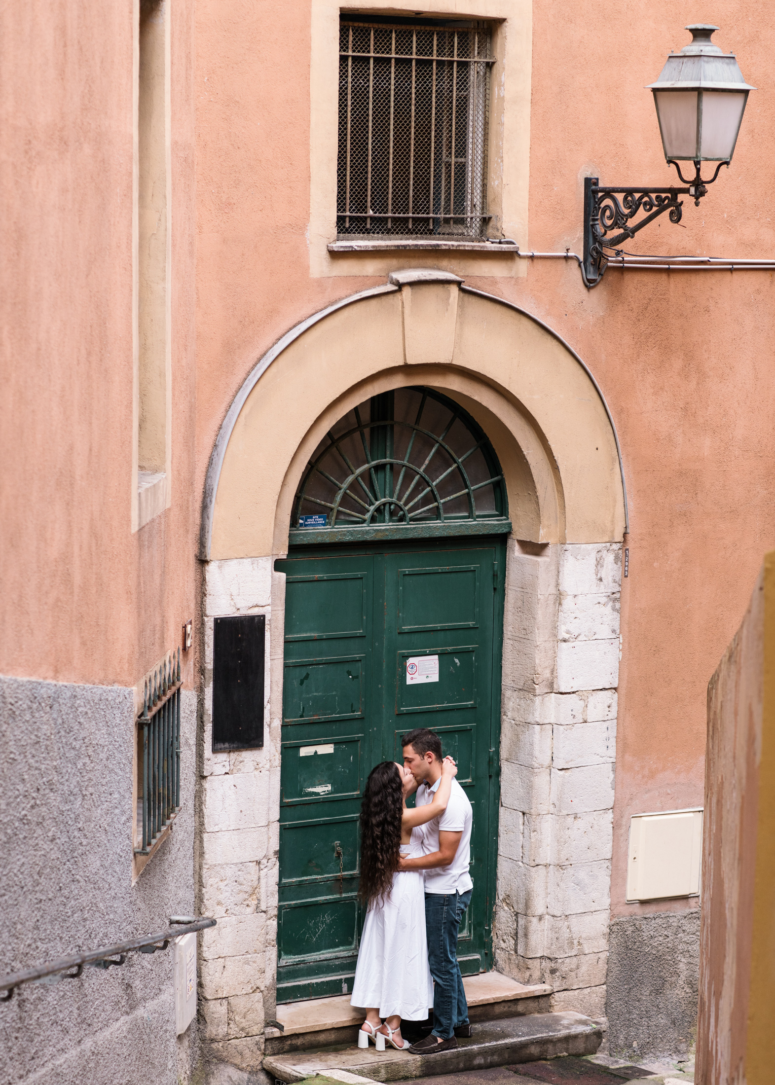 newly engaged couple kiss in front of green door in nice france