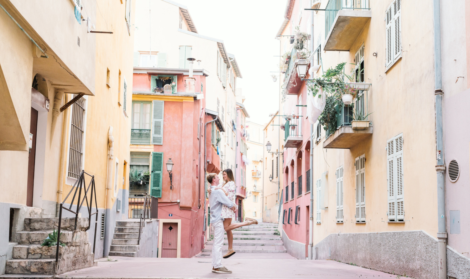 man lifts woman in air in the old part of nice france