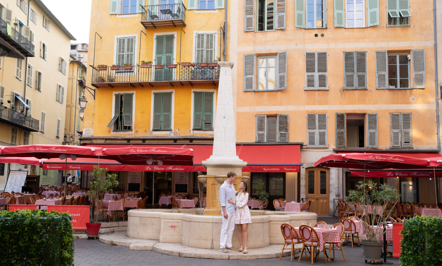 newly engaged couple pose in front of italian restaurant in nice france