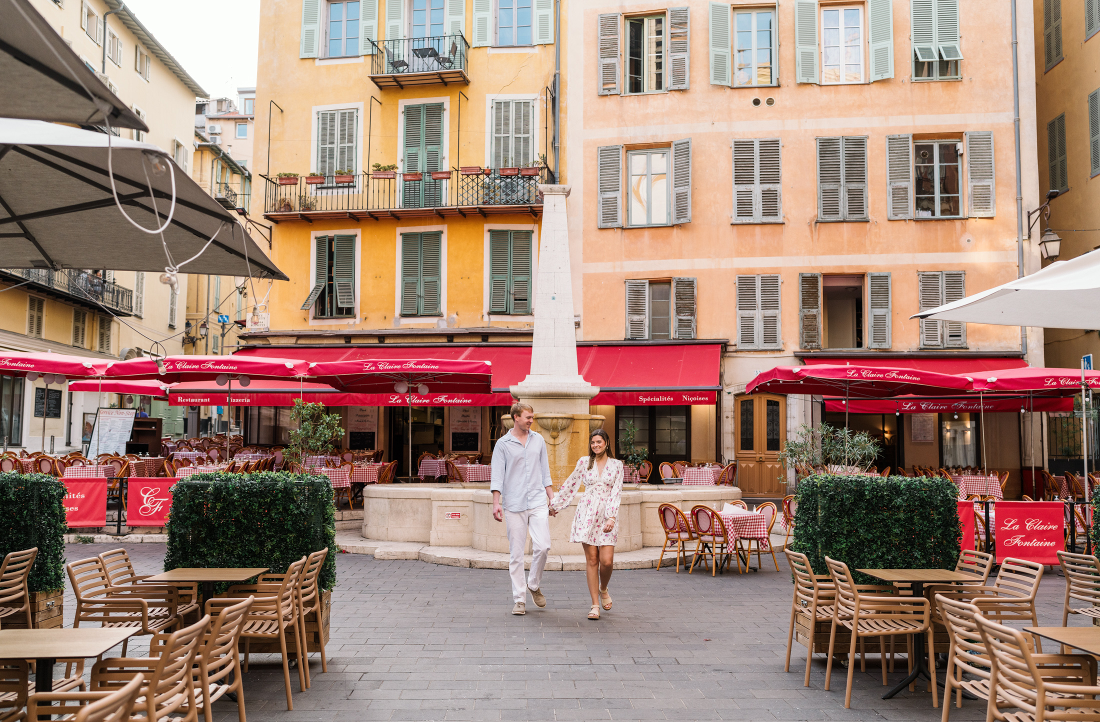 newly engaged couple walk next to italian restaurant in old nice france