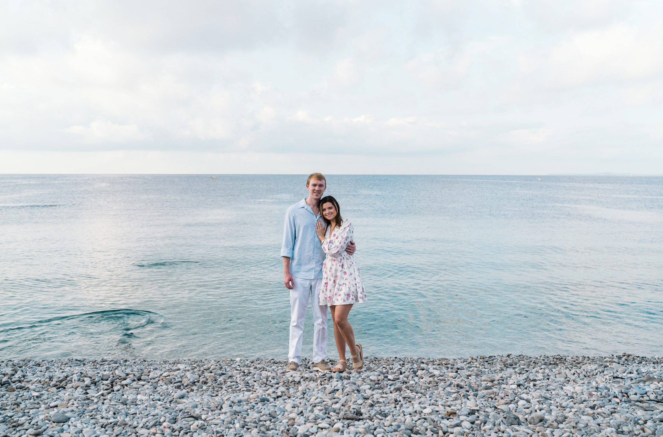 newly engaged couple pose next to sea in nice france