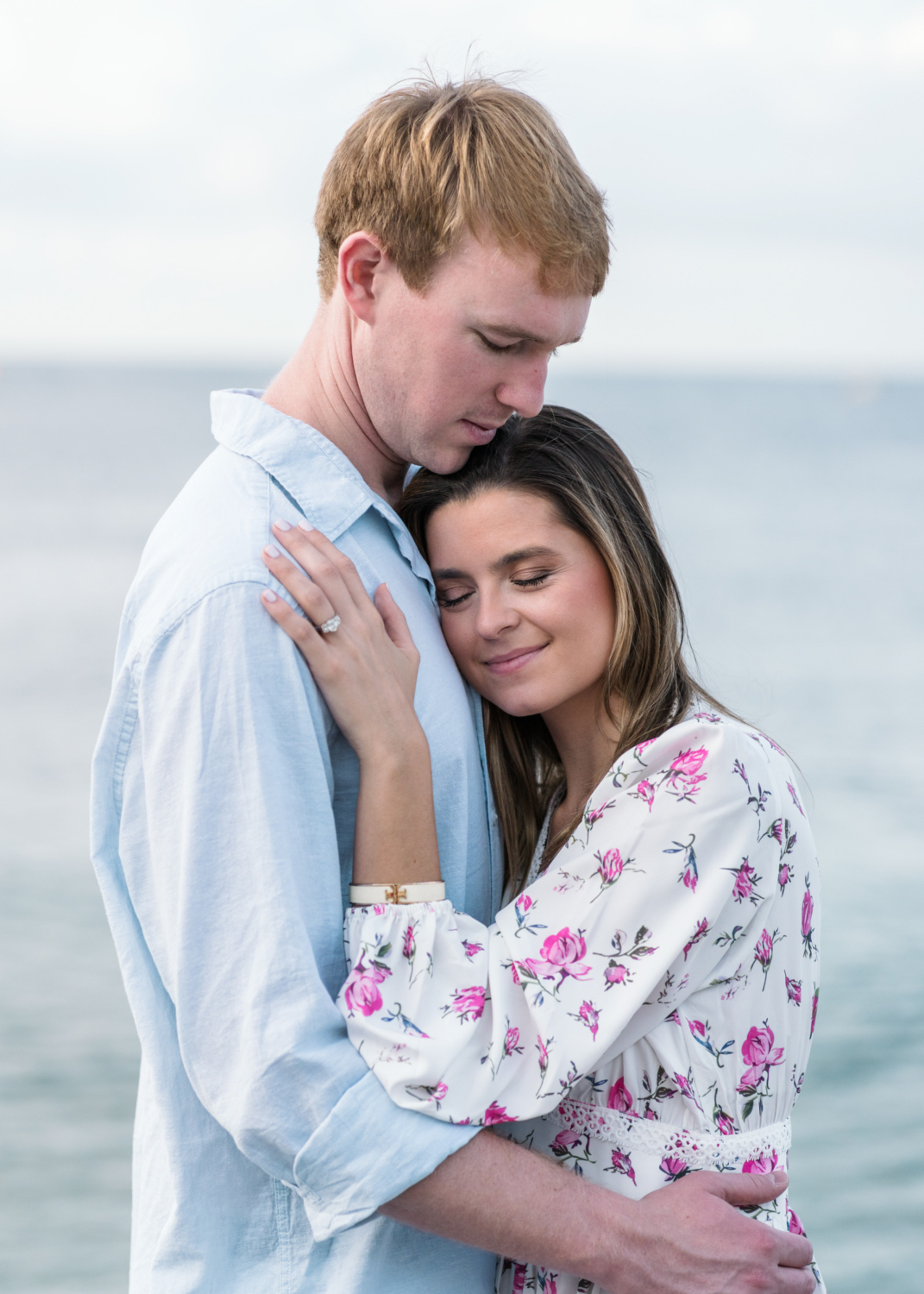 newly engaged couple embrace on beach in nice france