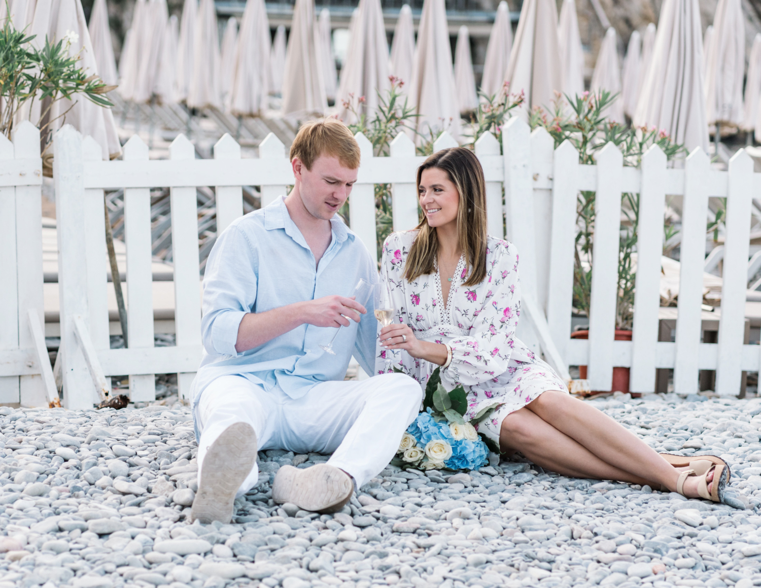 newly engaged couple toast with champagne on beach in nice france