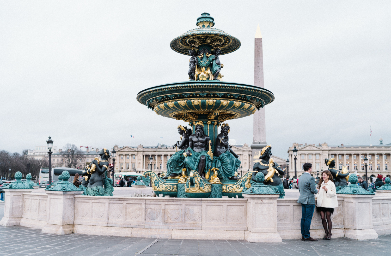 newly engaged couple laugh and drink champagne place de la concorde paris