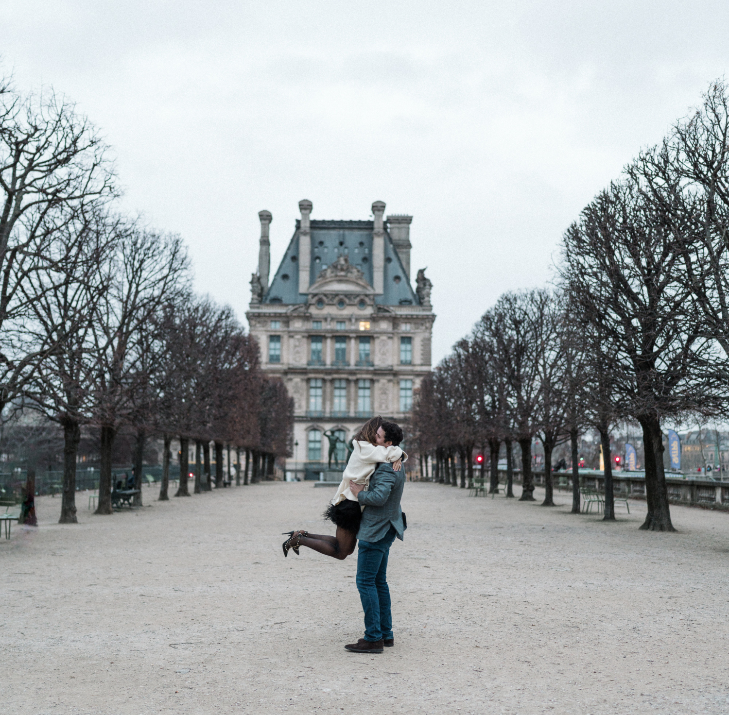 man twirls woman after engagement in paris