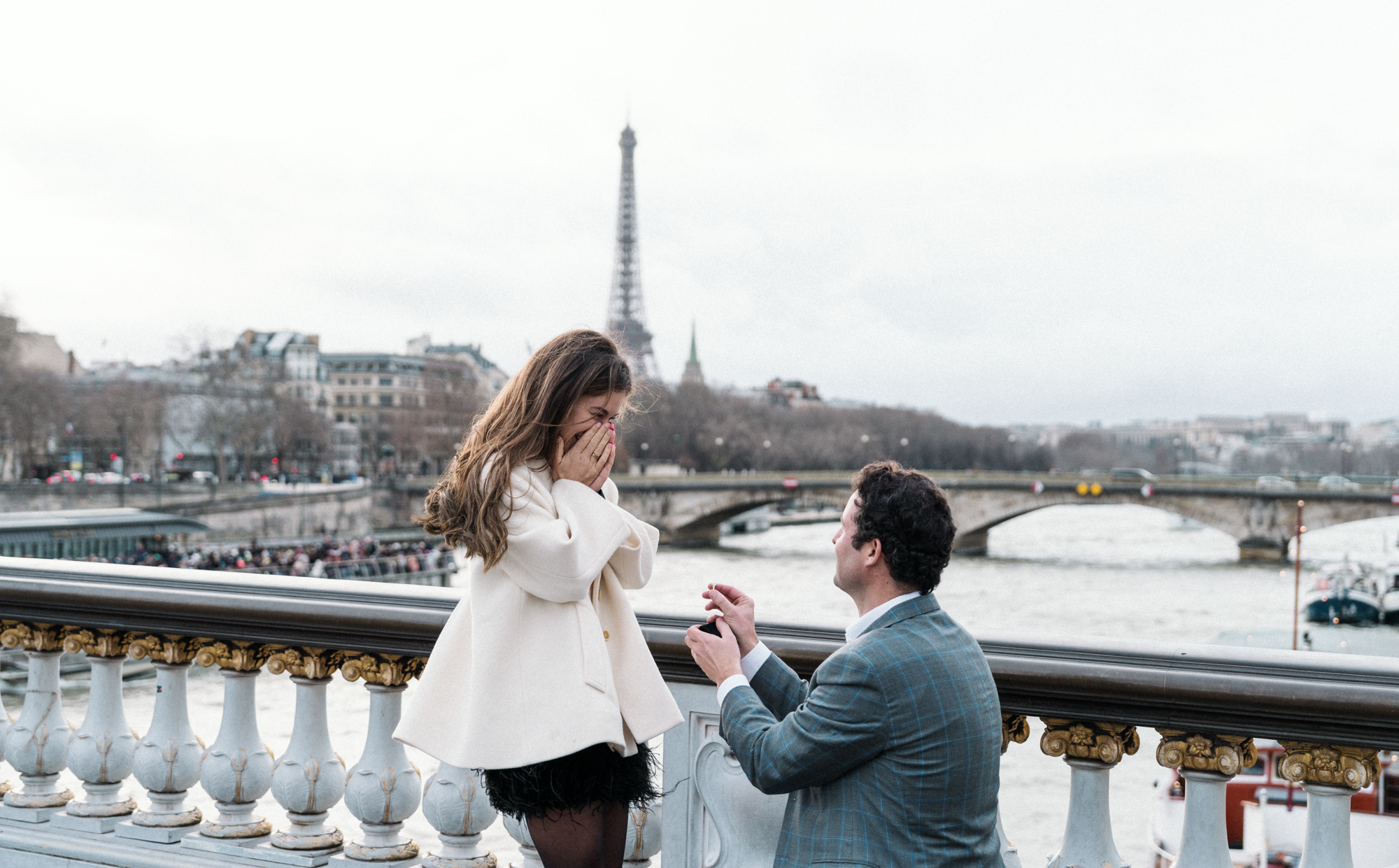 woman surprised as man presents diamond engagement ring in paris