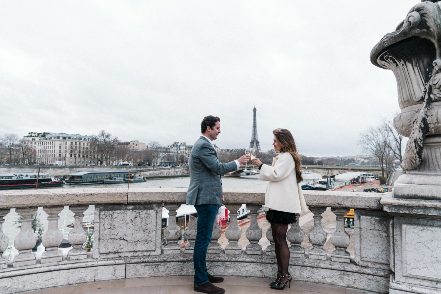 newly engaged couple toast with champagne with view of eiffel tower