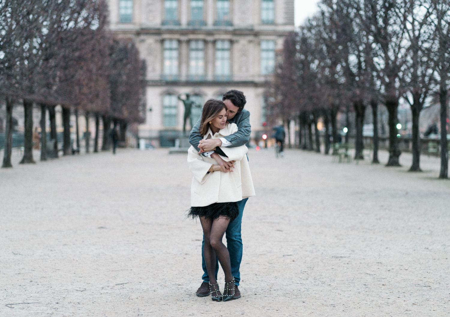 man hugs woman in jardin de tuileries paris