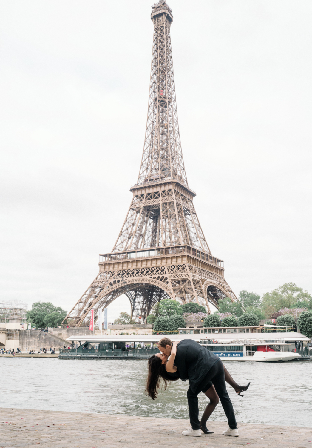 man dips woman in dance with eiffel tower view