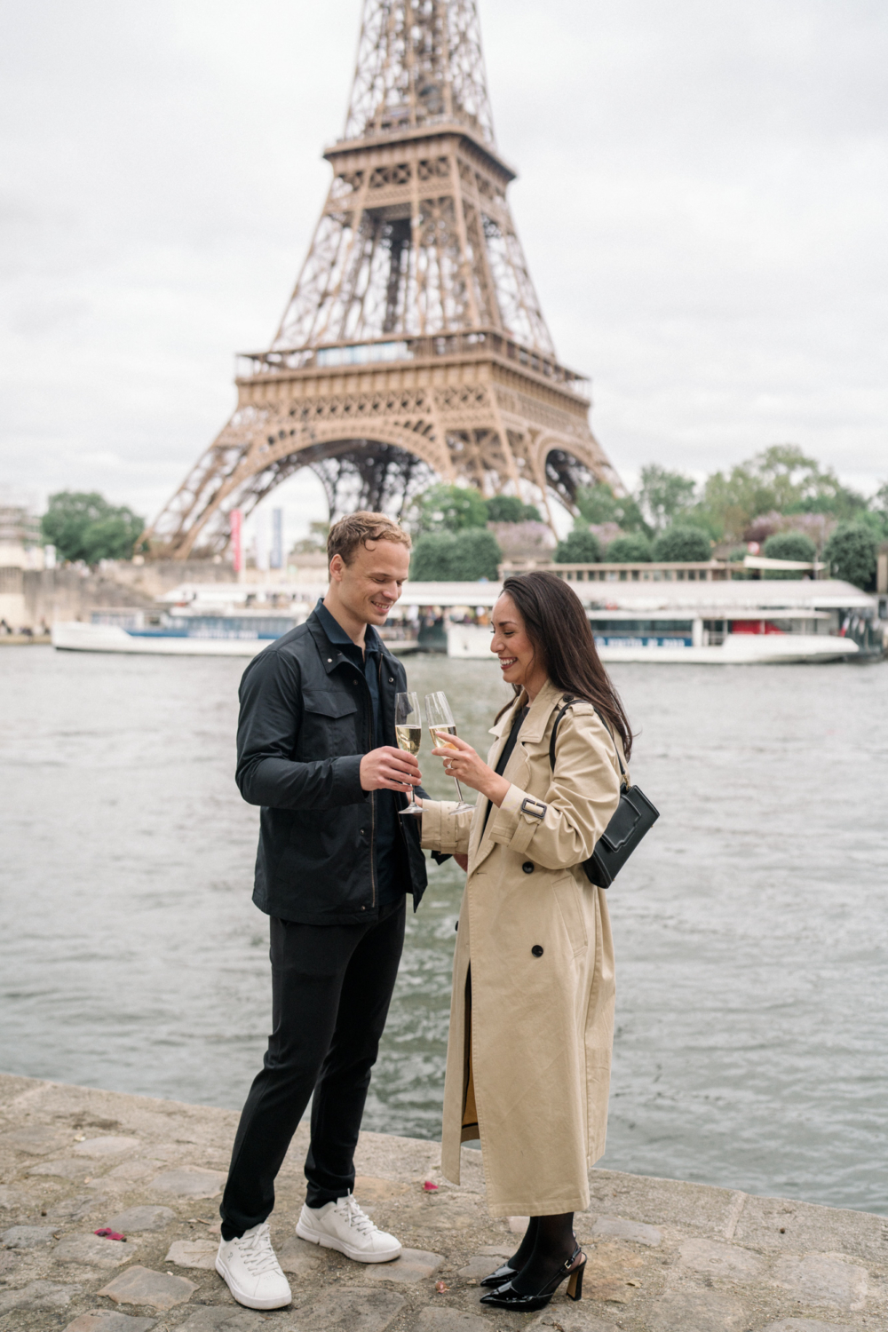 couple toast their engagement with champagne at eiffel tower