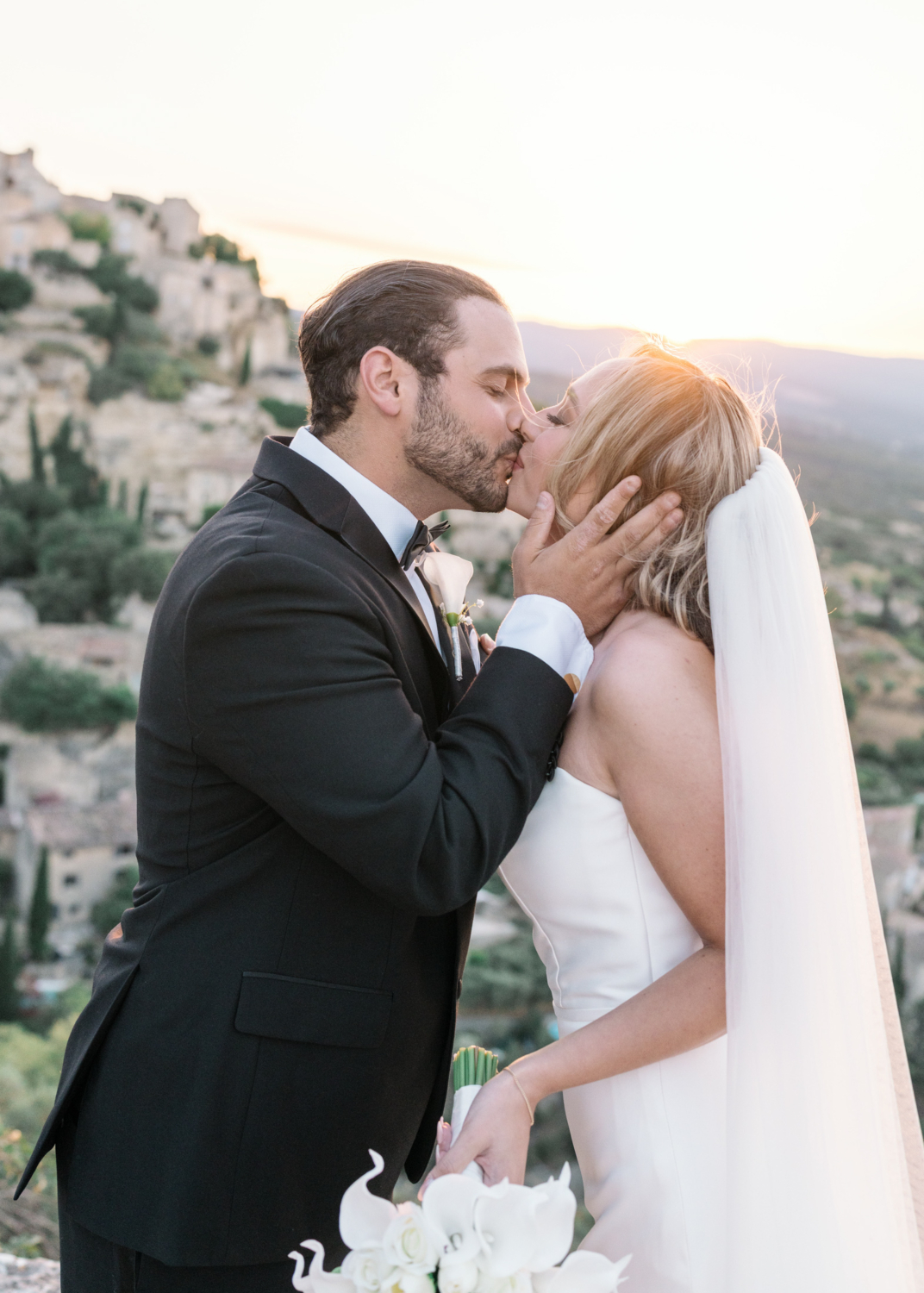 bride and groom kiss at sunrise in gordes france