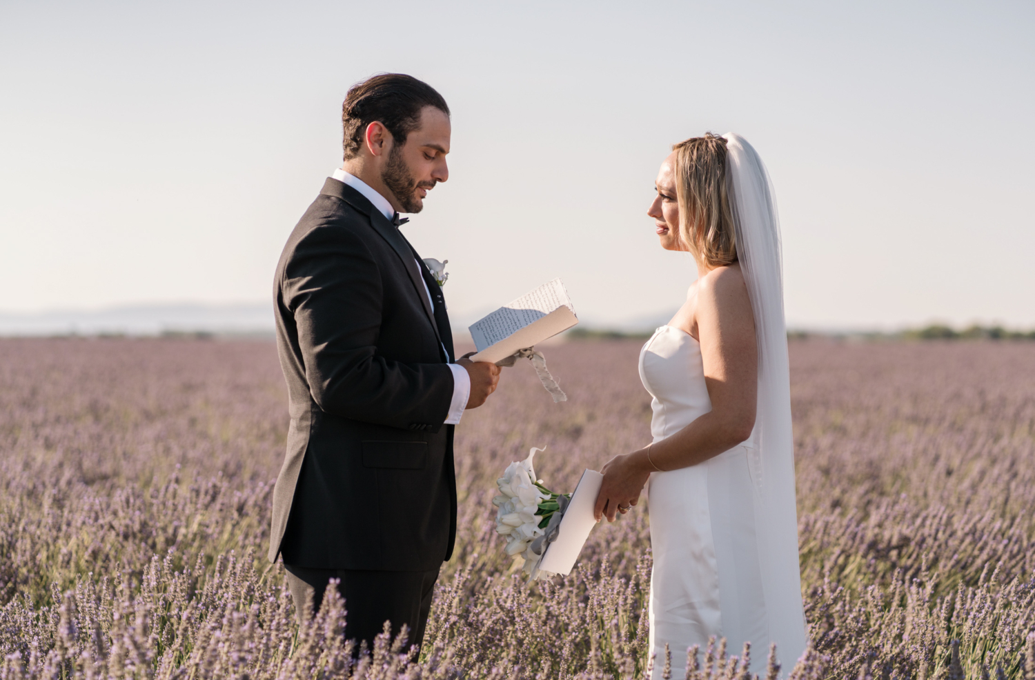 groom reads vows to bride in lavender field in provence