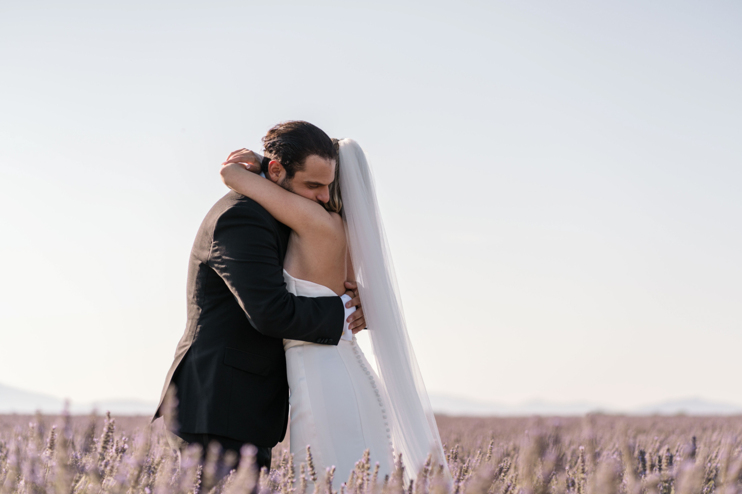 bride and groom embrace after their ceremony in a lavender field in provence