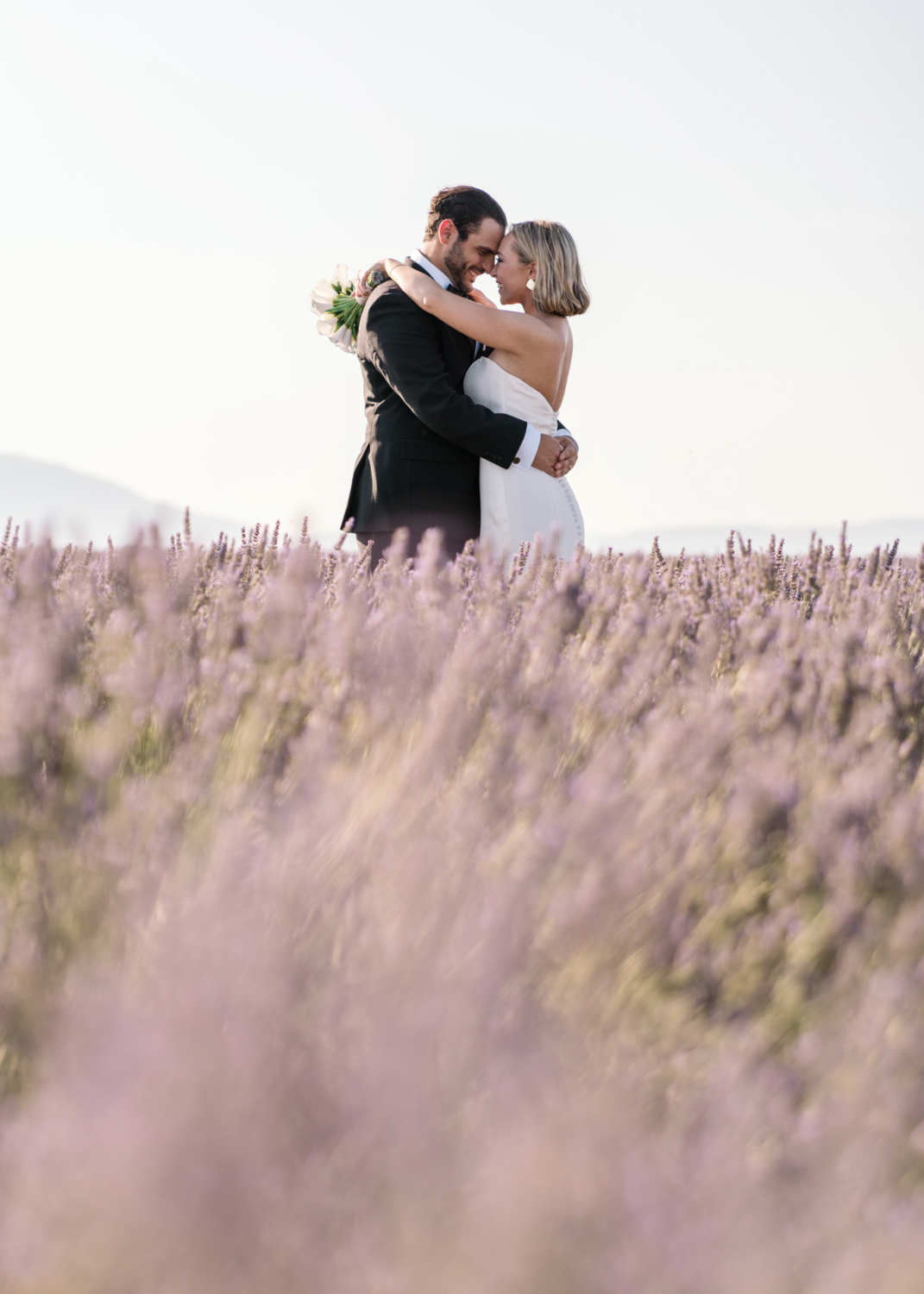 bride and groom embrace in lavender field in provence france