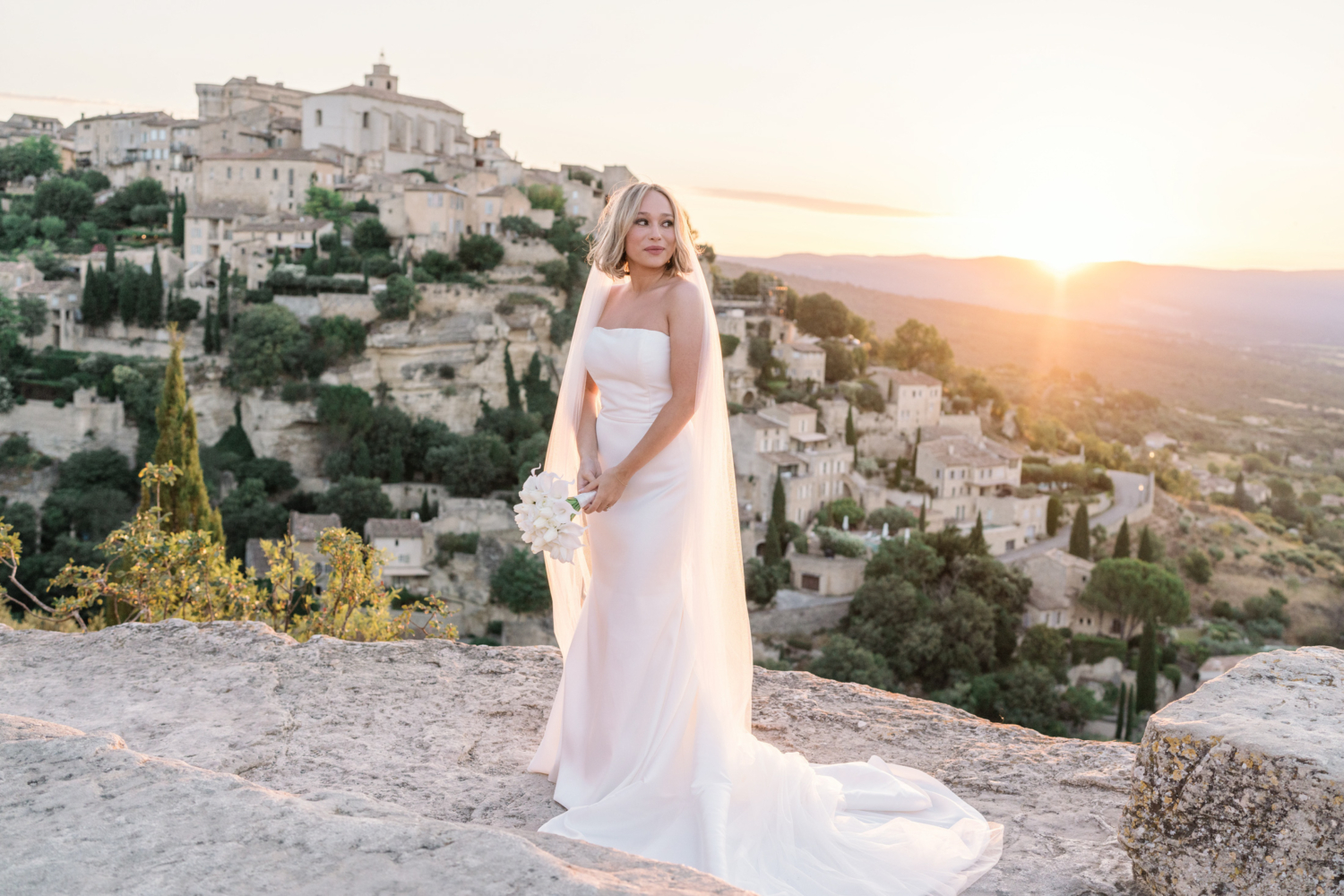 bride poses on her wedding day at sunrise in gordes france