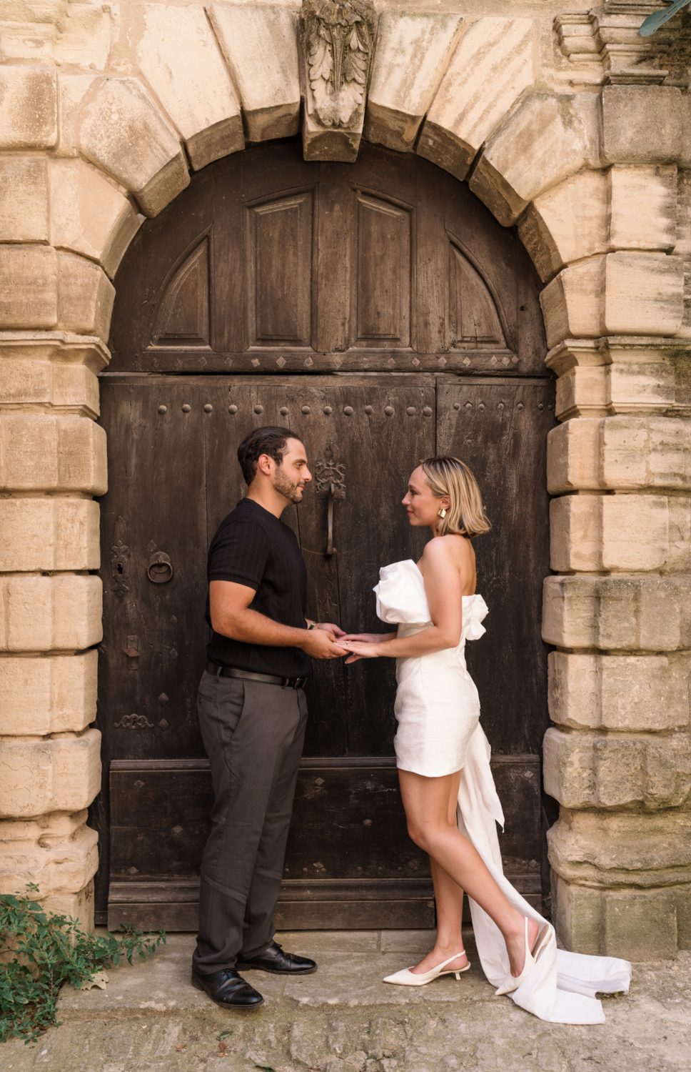 bride and groom pose in front of old door in gordes france