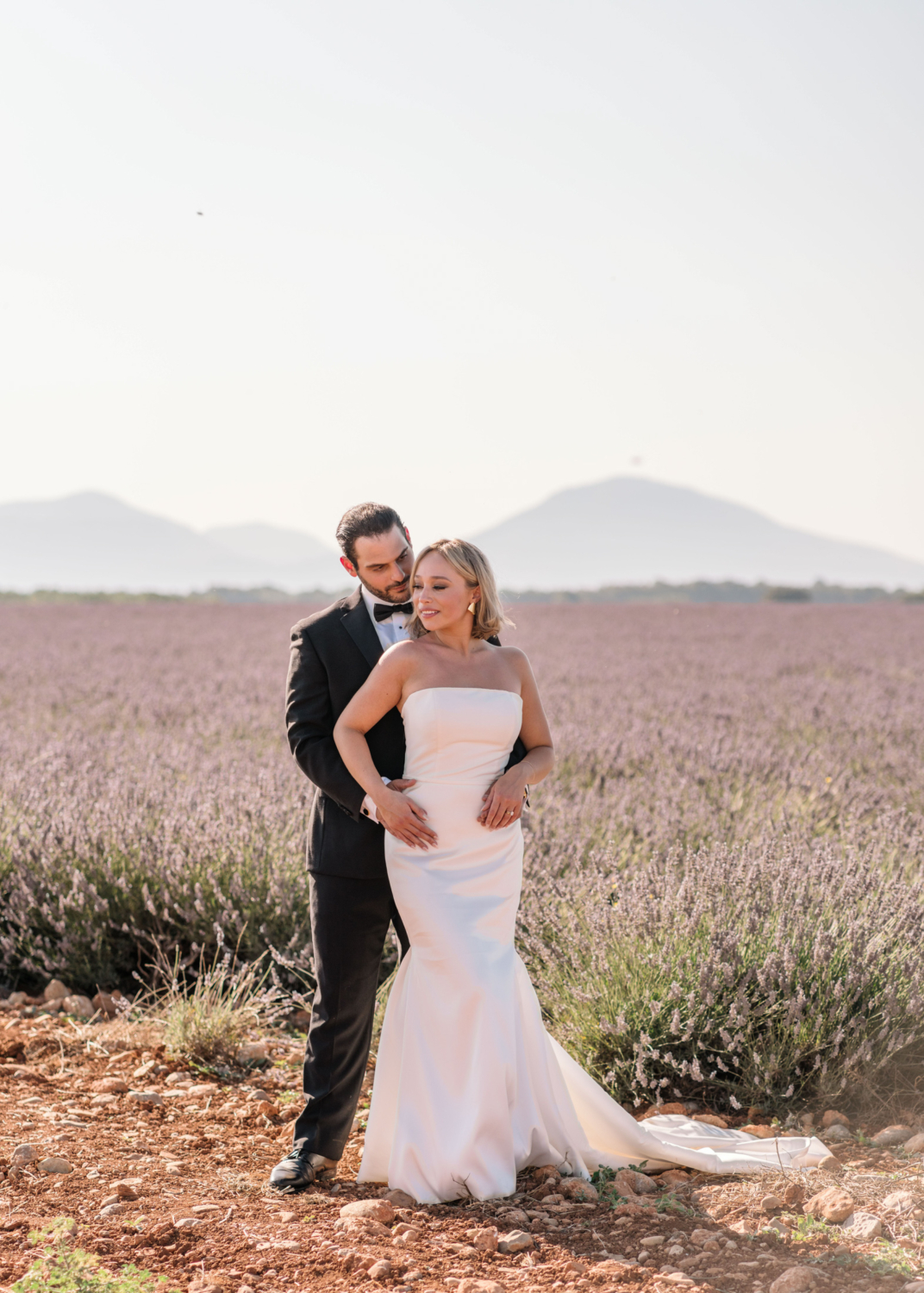 bride and groom pose elegantly in lavender field in provence