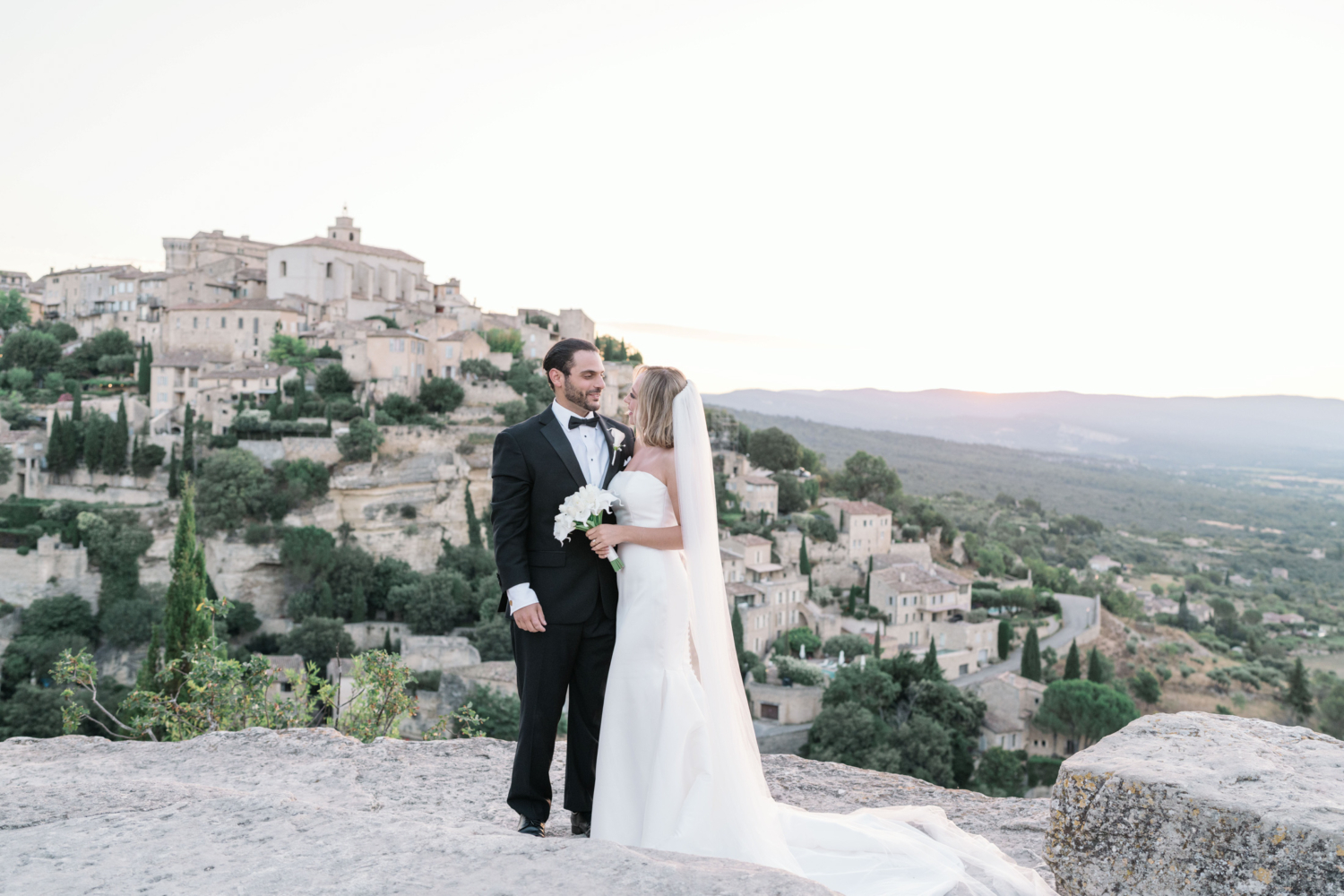 bride and groom pose on their wedding day in gordes france