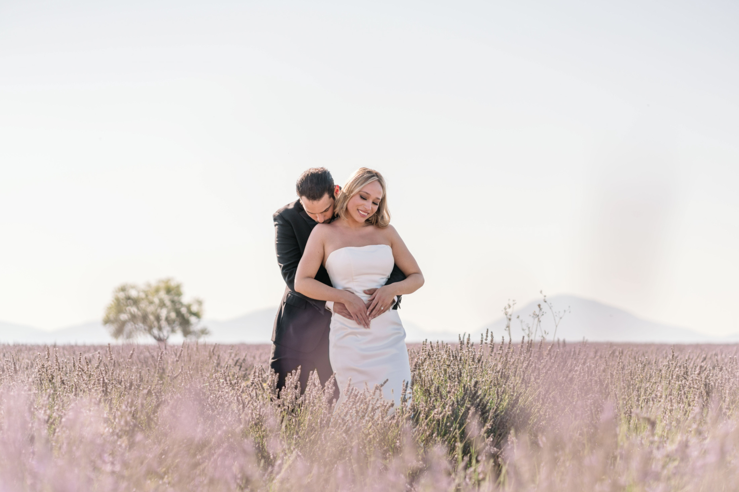 bride and groom embrace in lavender field in provence