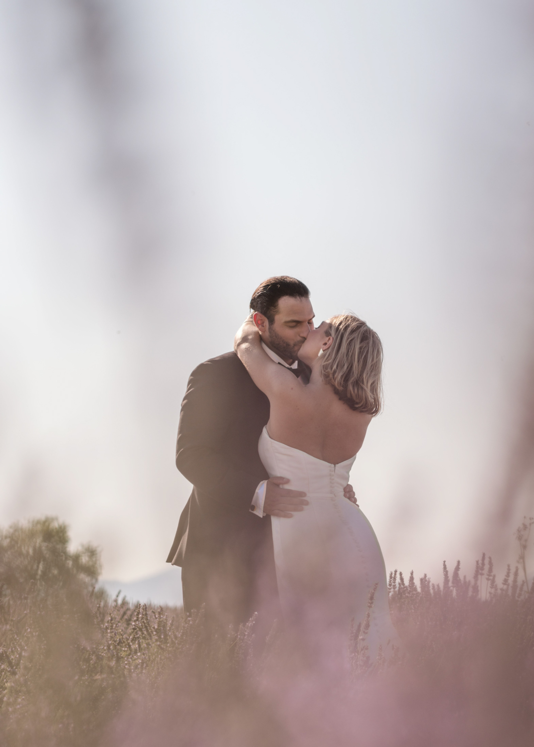 bride and groom kiss in lavender field