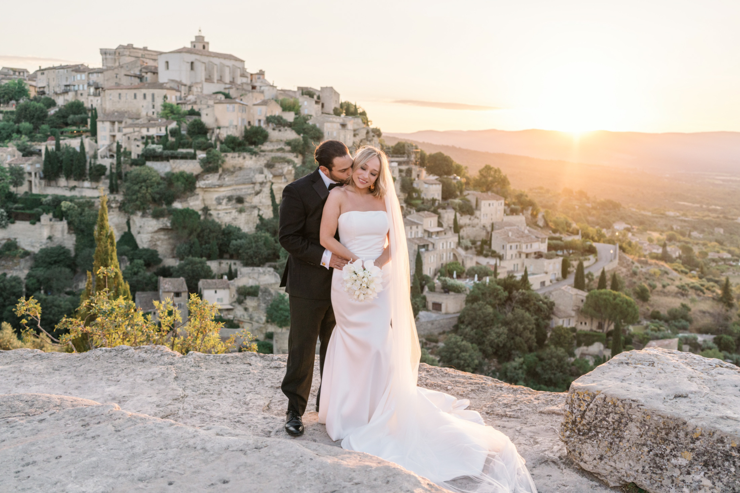 bride and groom embrace in gordes france at sunrise