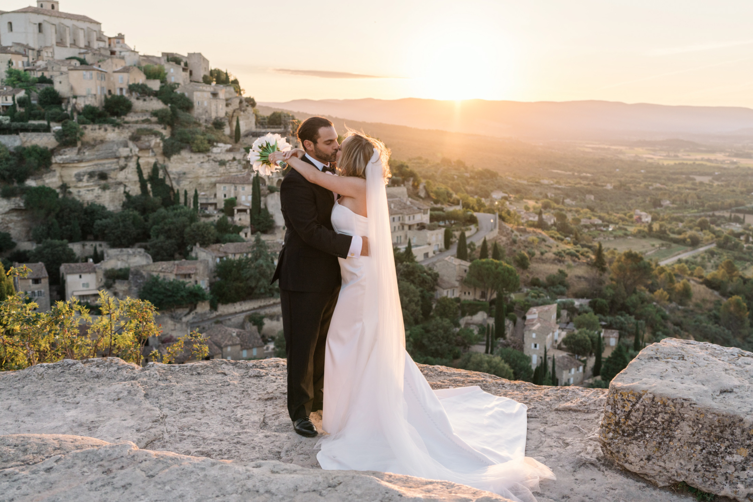 bride and groom kiss at sunrise in gordes france