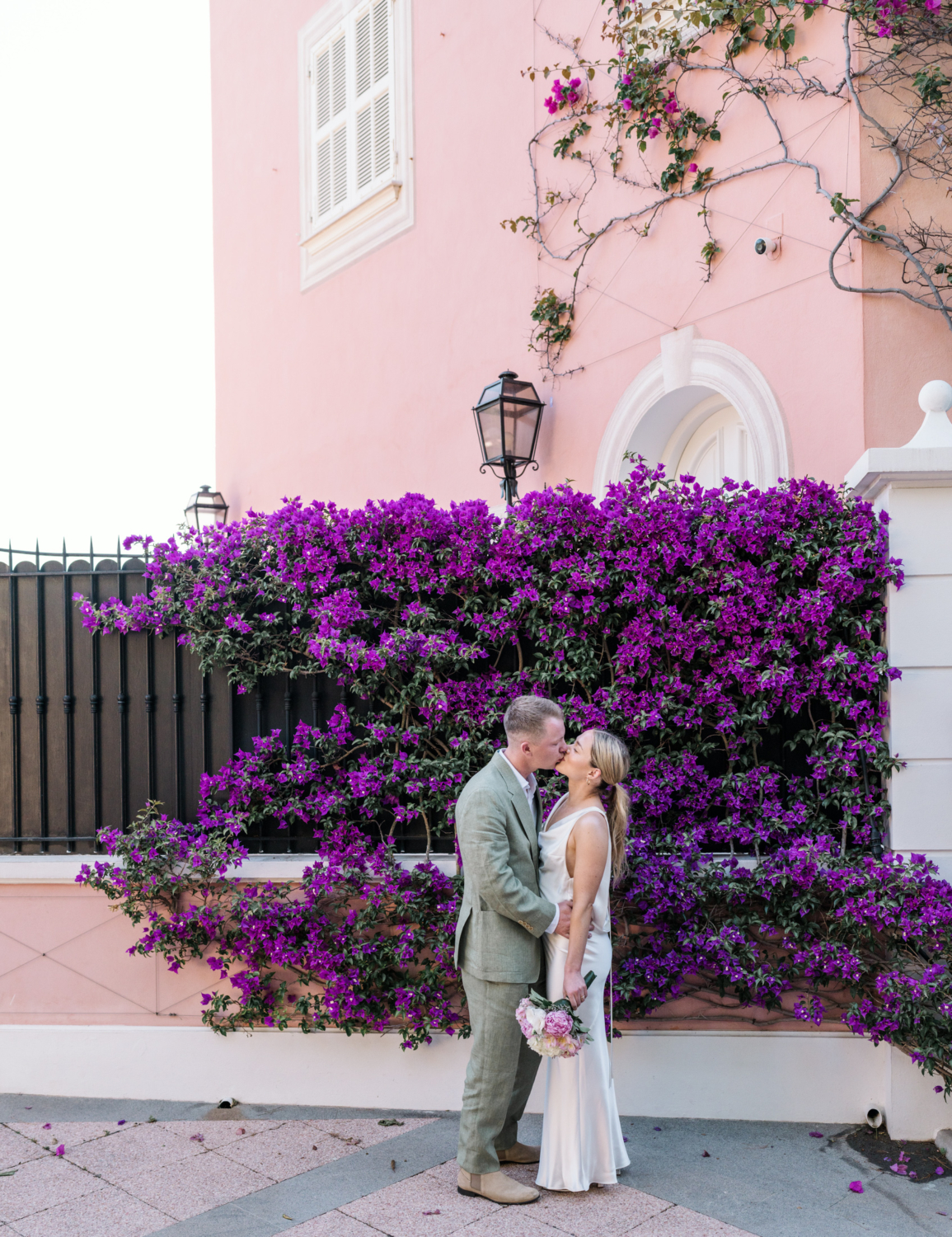 bride and groom kiss in front of pink villa saint jean cap ferrat