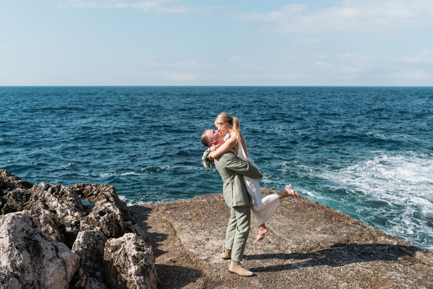 groom lifts bride in air on french riviera