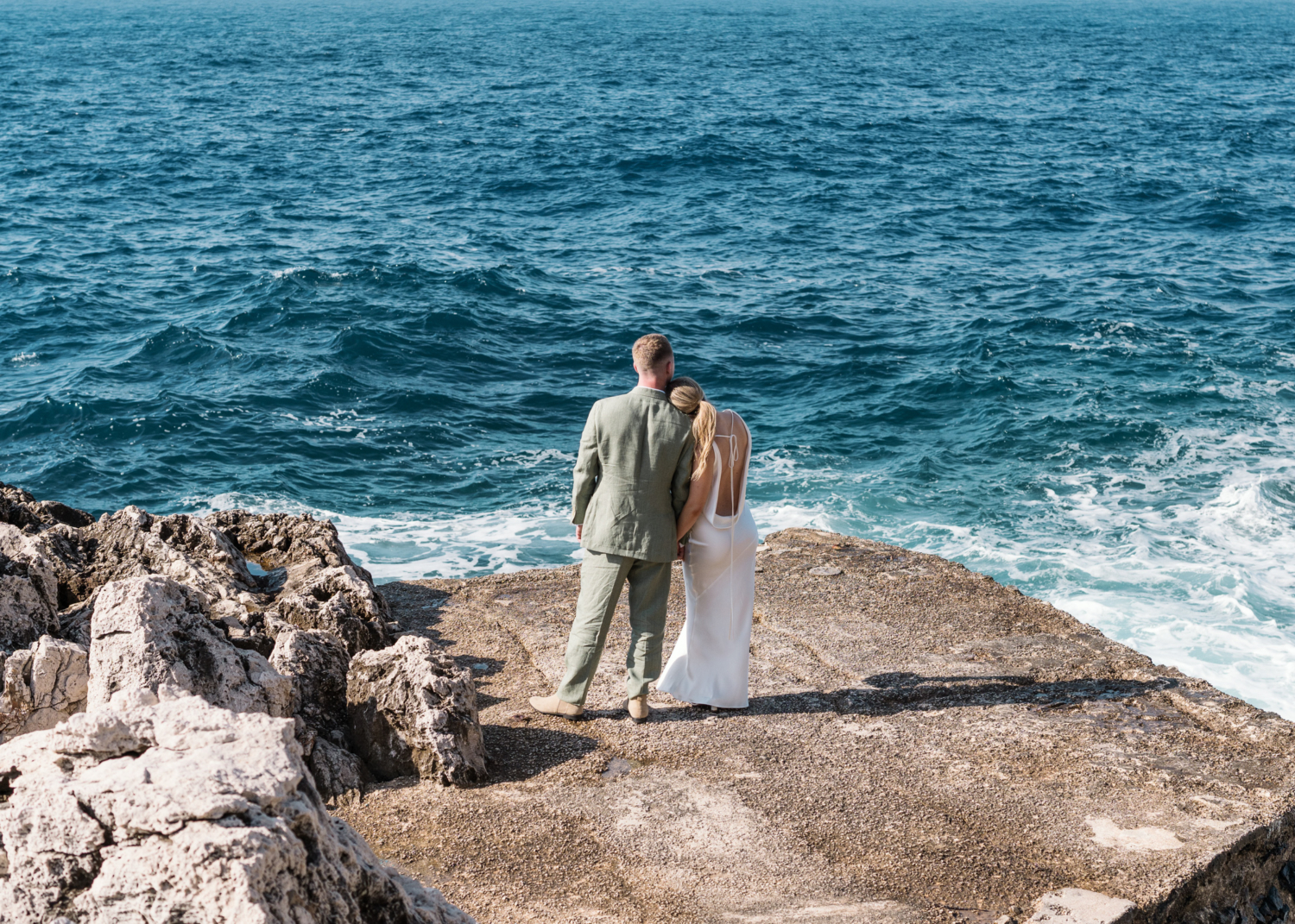 bride lays head on grooms shoulder with sea view on french riviera