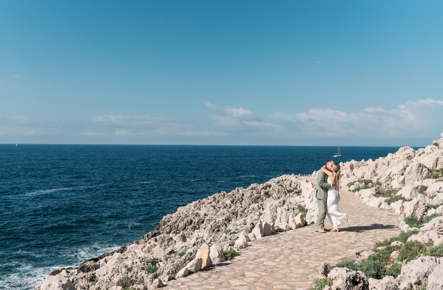 bride and groom kiss with view of the sea in saint jean cap ferrat france