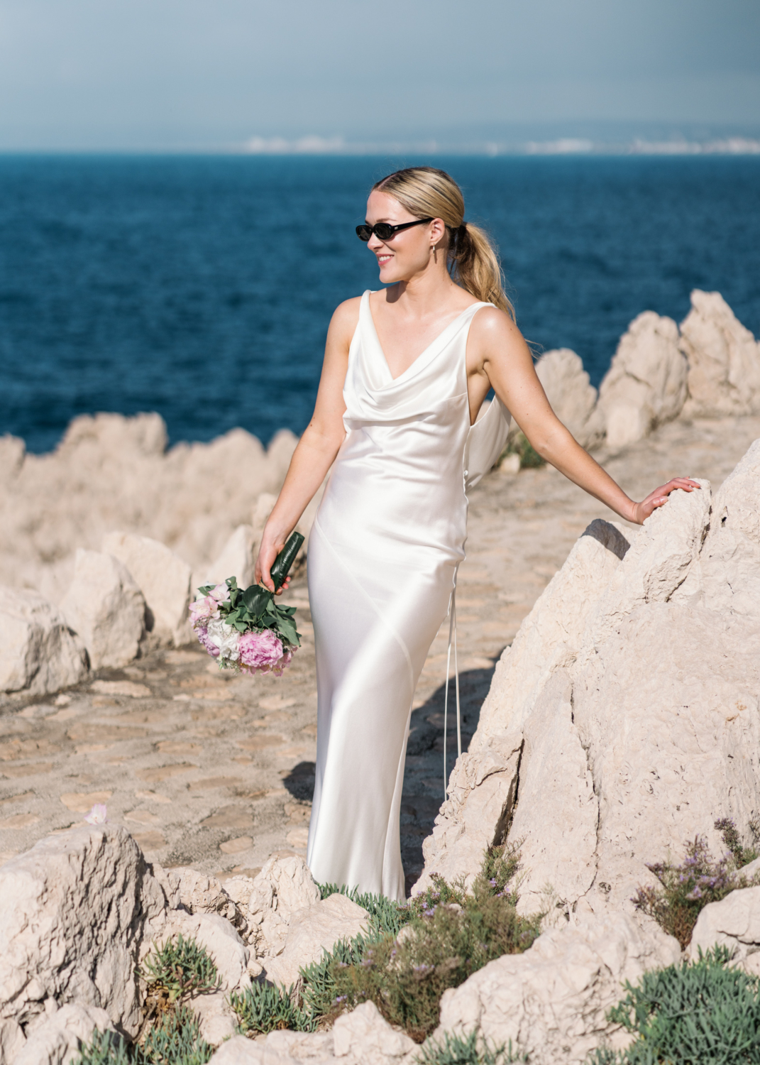 bride smiles holding bouquet on the french riviera