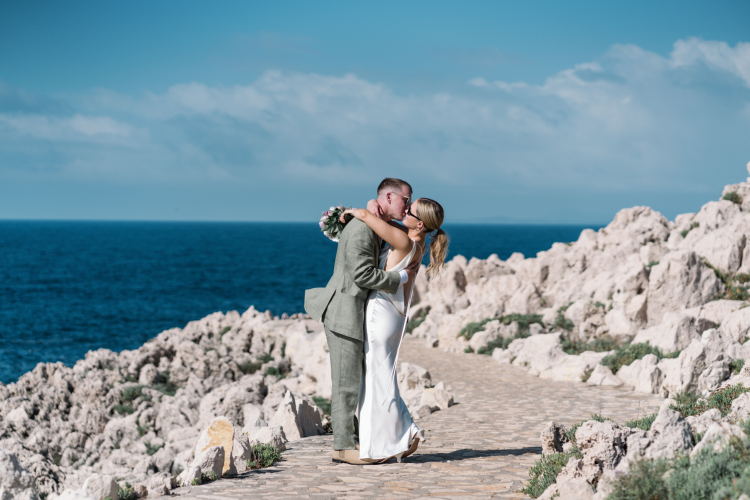 bride and groom embrace with view of the sea in saint jean cap ferrat france