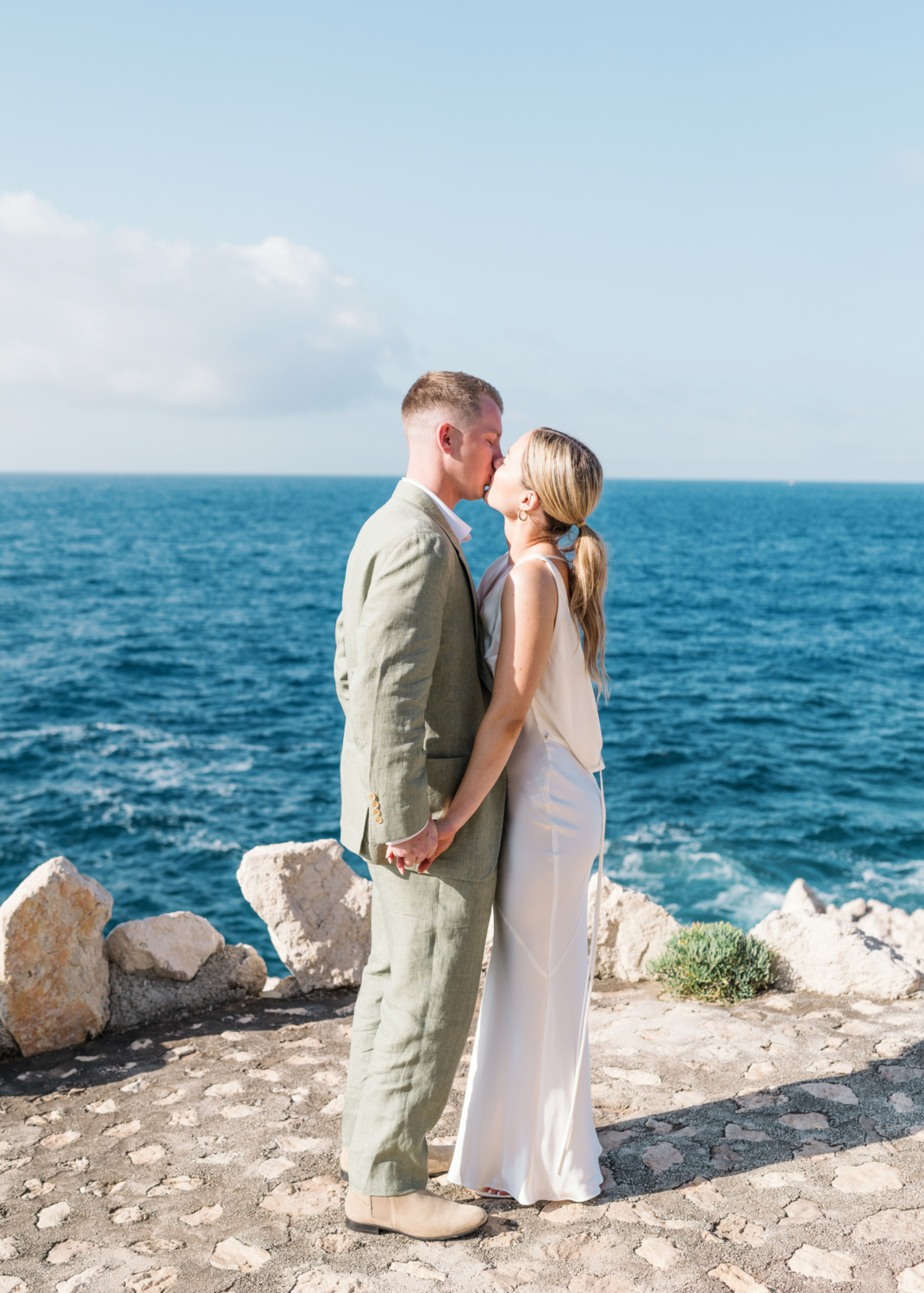 bride and groom kiss passionately with view of sea on french riviera