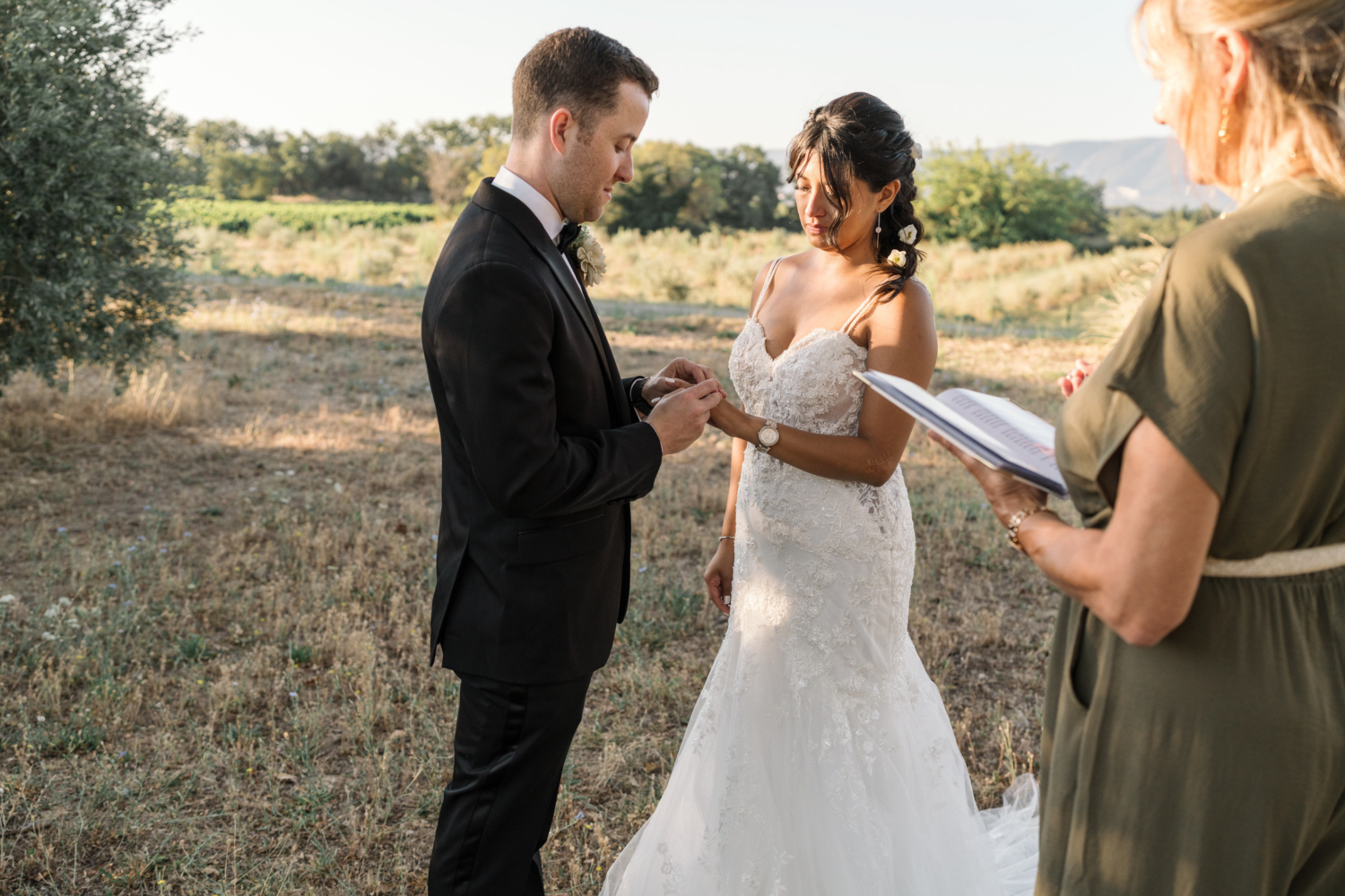 bride and groom exchange rings on their wedding day in olive grove in provence