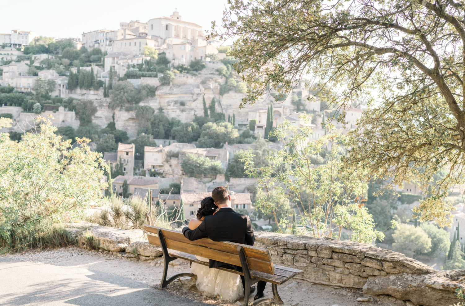 bride and groom relax on bench in gordes france