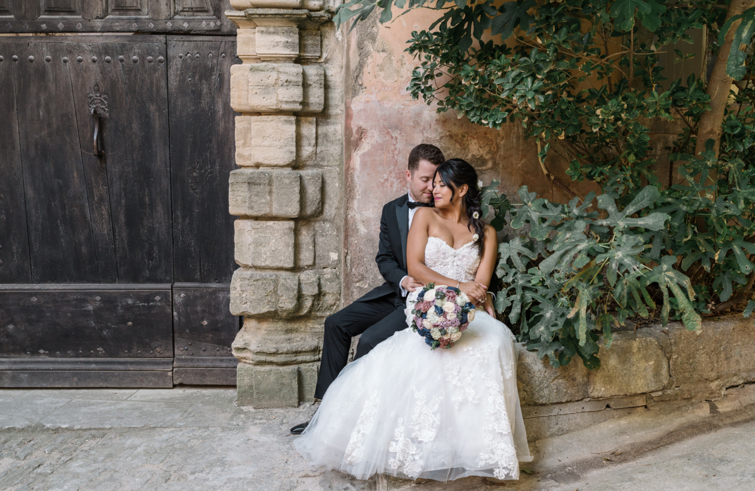 bride and groom embrace in gordes france against orange wall