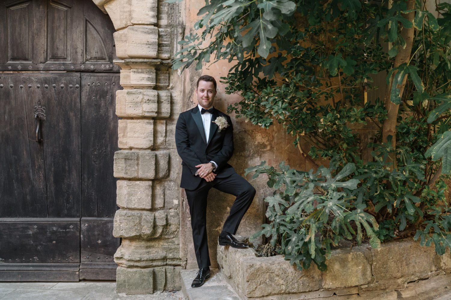 groom poses in gordes france on his wedding day