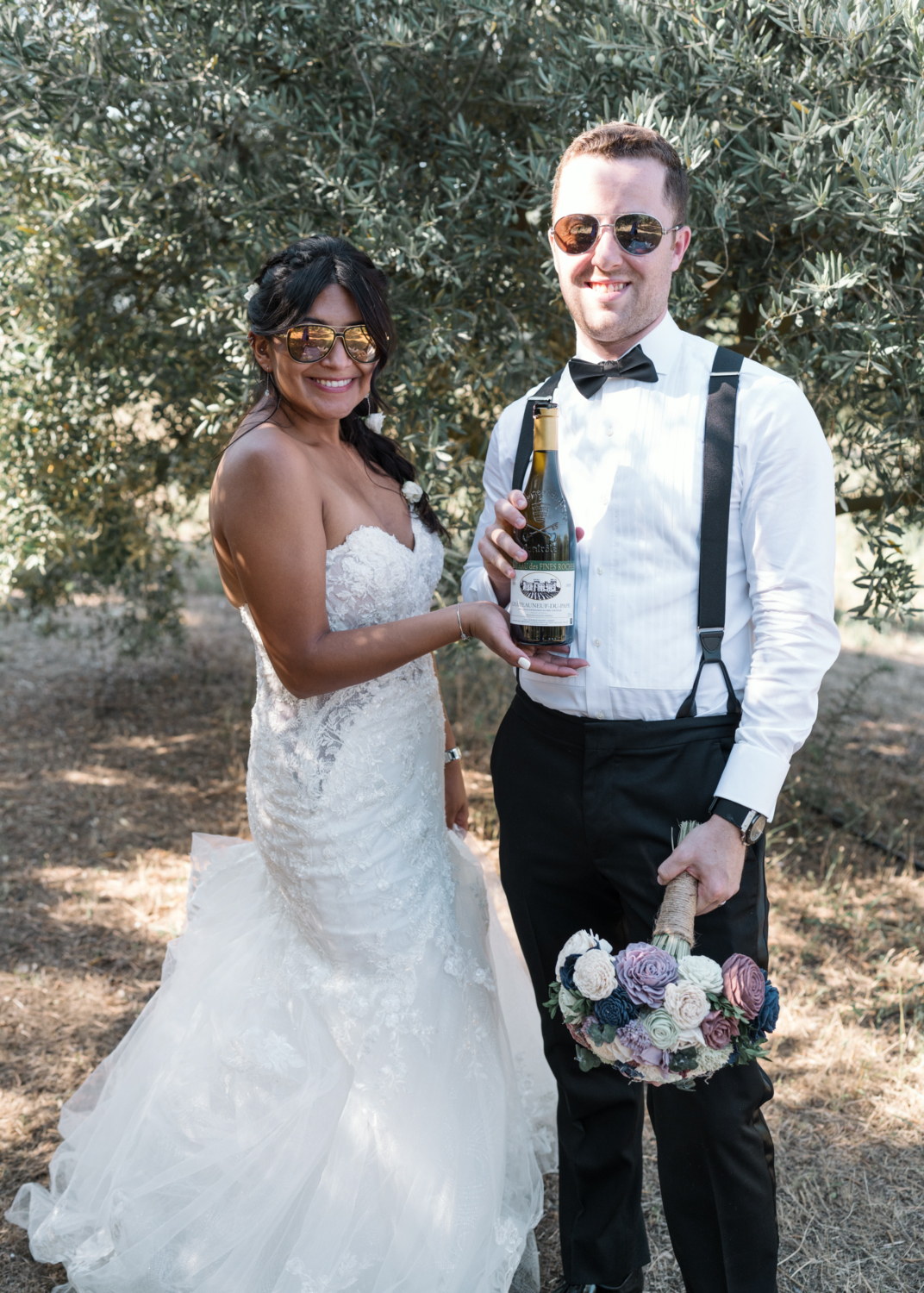 bride and groom show off wine bottle in provence france