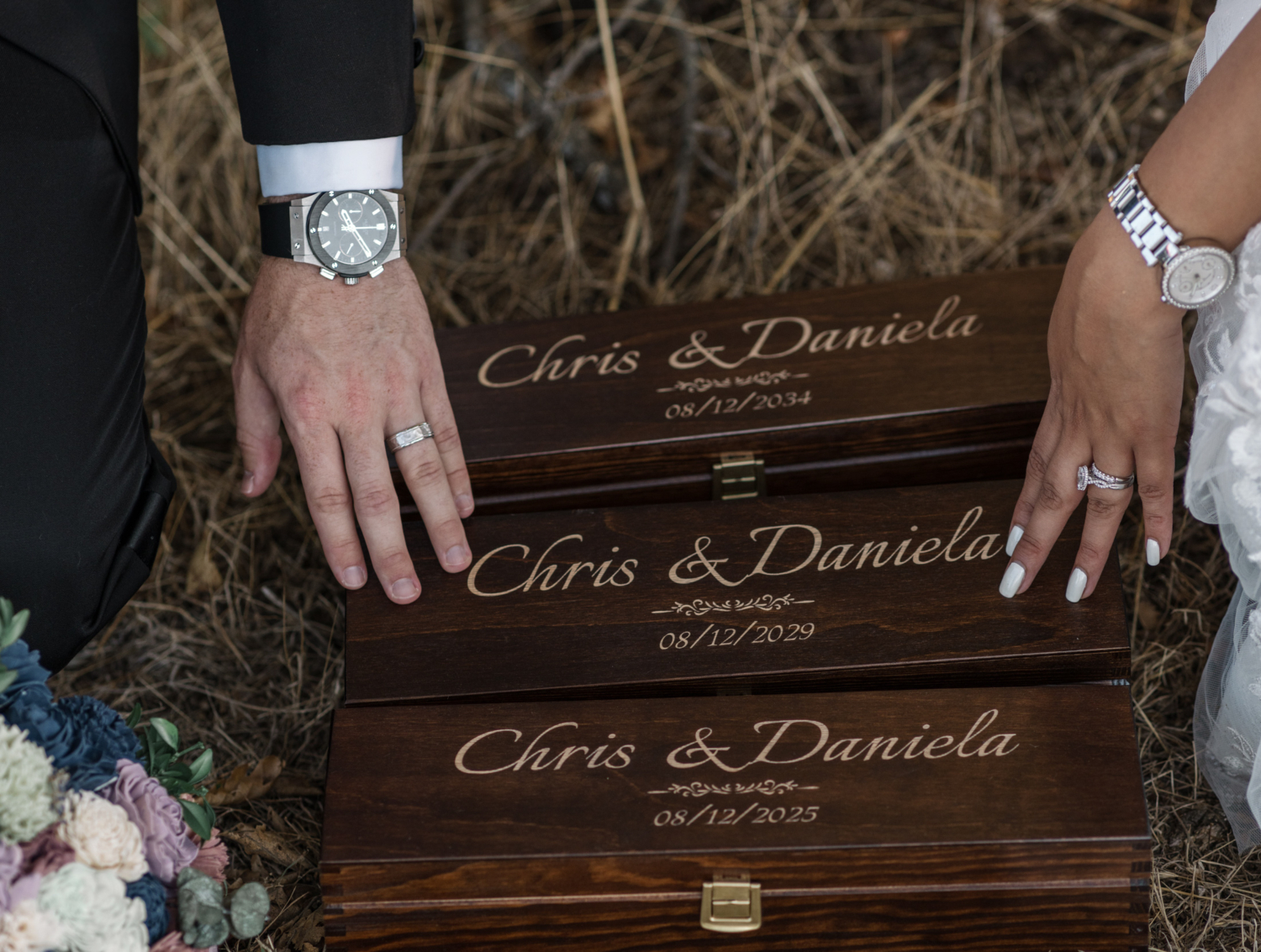 bride and groom touch engraved boxes on wedding day