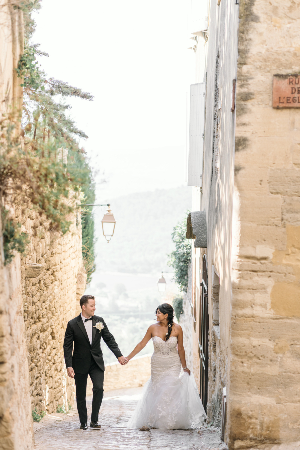 newlyweds walk through the streets of gordes france