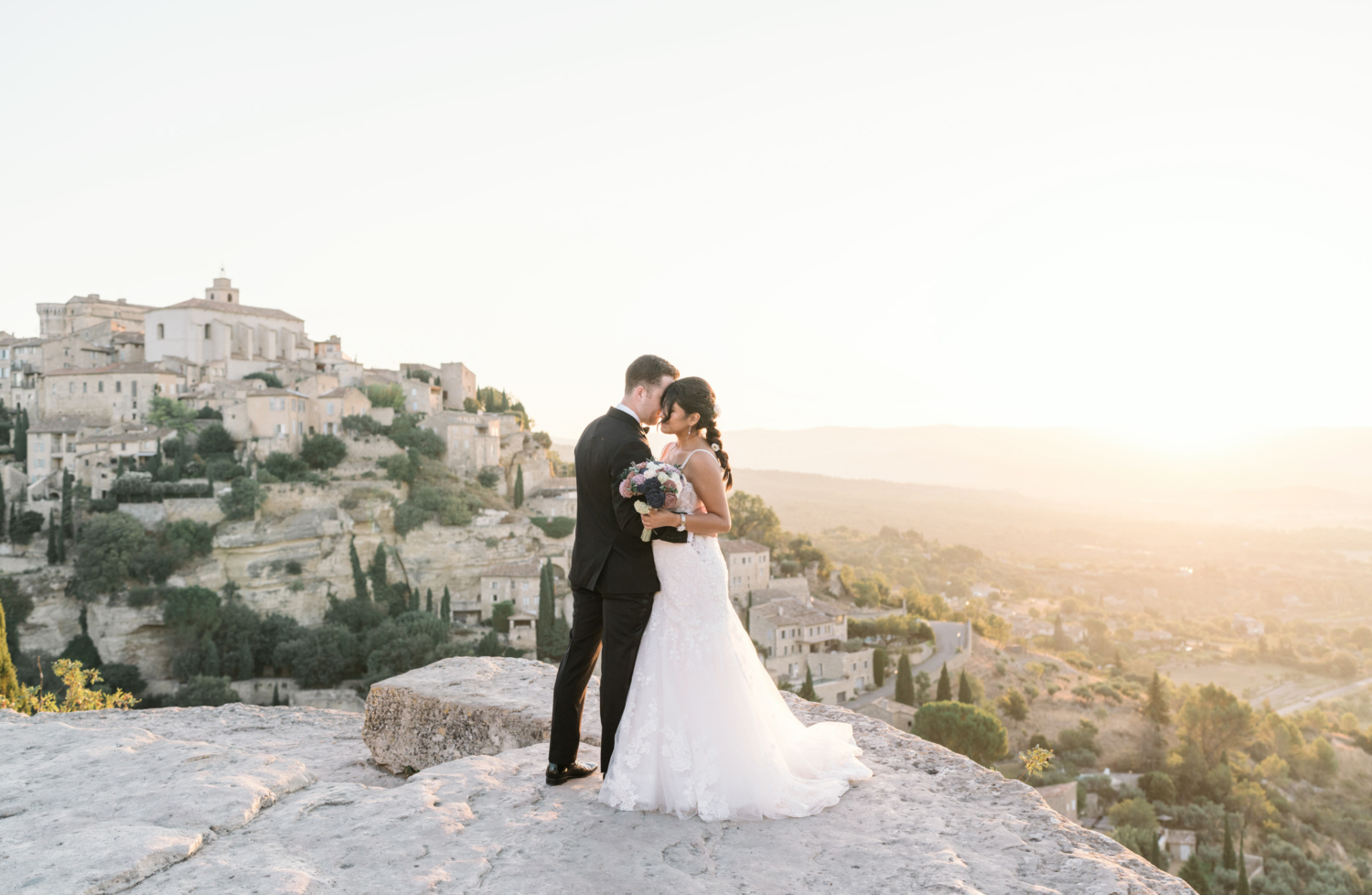 groom whispers in ear of bride in gordes france