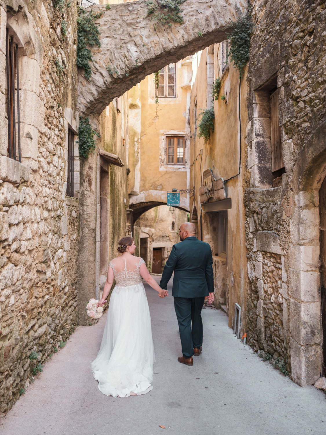 bride and groom smile at each other in medieval french village