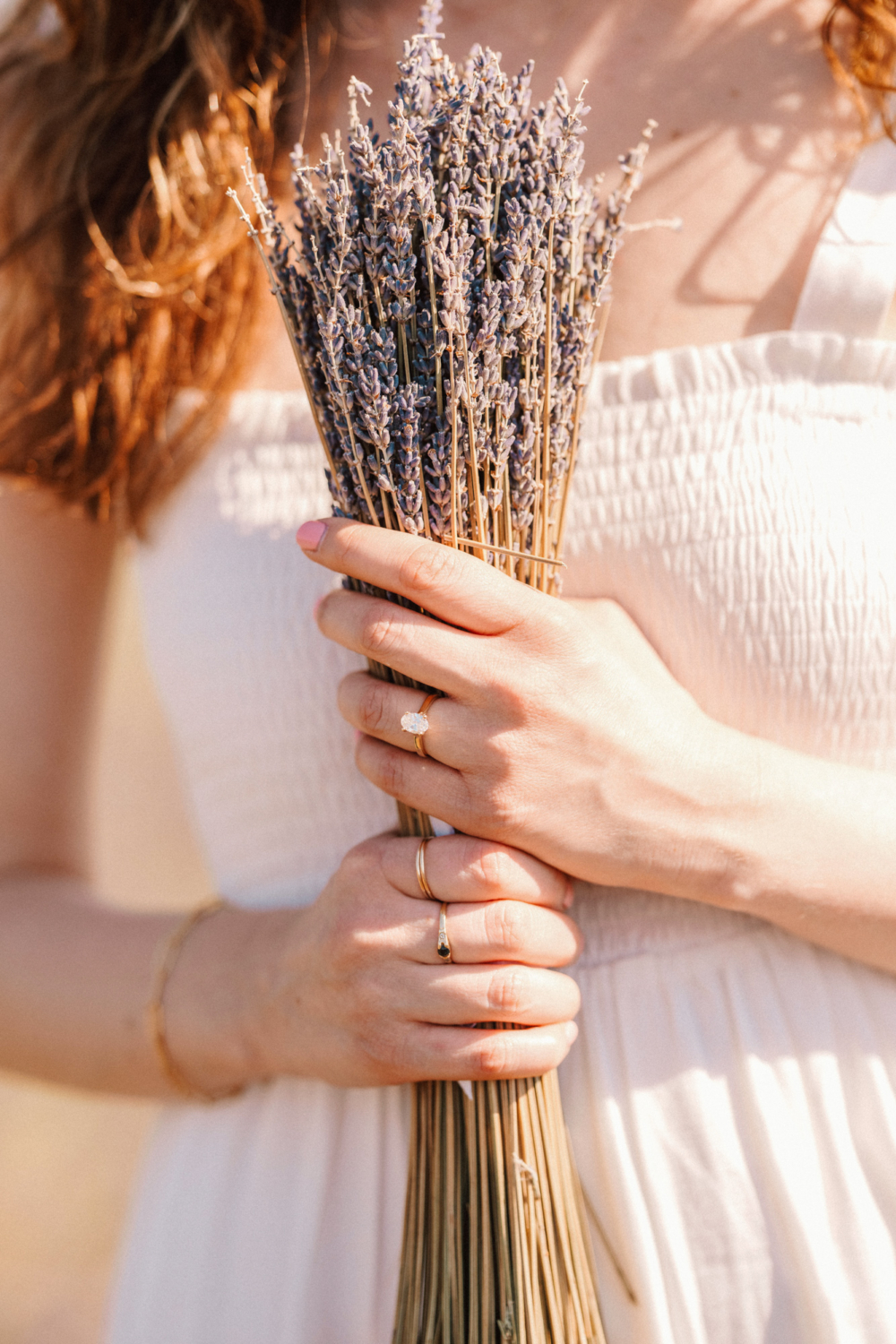 woman holds lavender wearing engagement ring